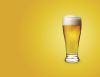 Glass of beer on colored background