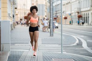 Woman athlete running on city street