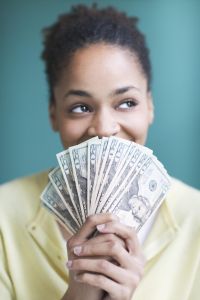 Young woman holding twenty dollar bills